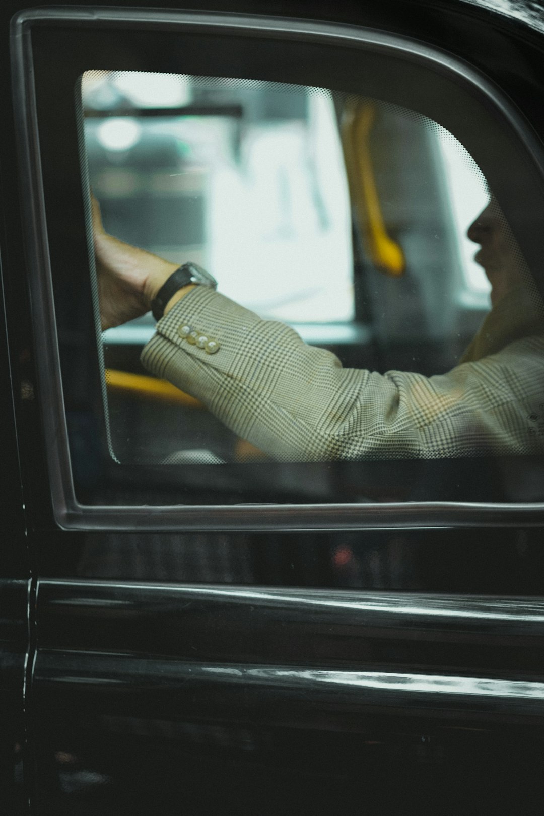 A rider relaxing in the comfortable back seat of a chauffeured car